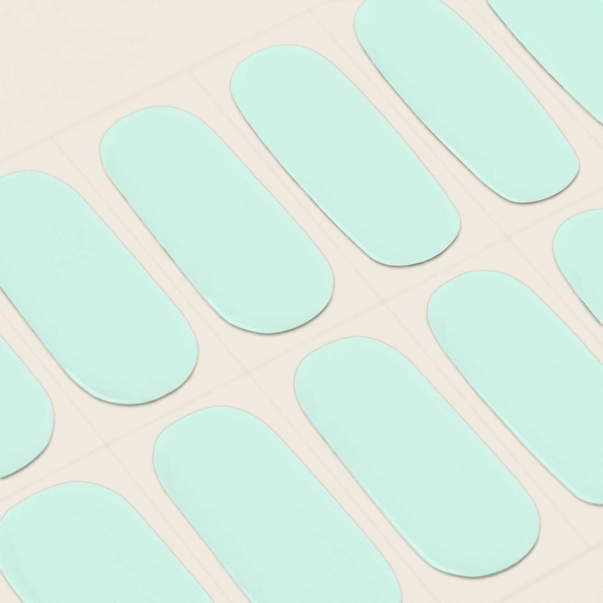 Close-up of seafoam mint mesme gel nail wraps on a sheet.