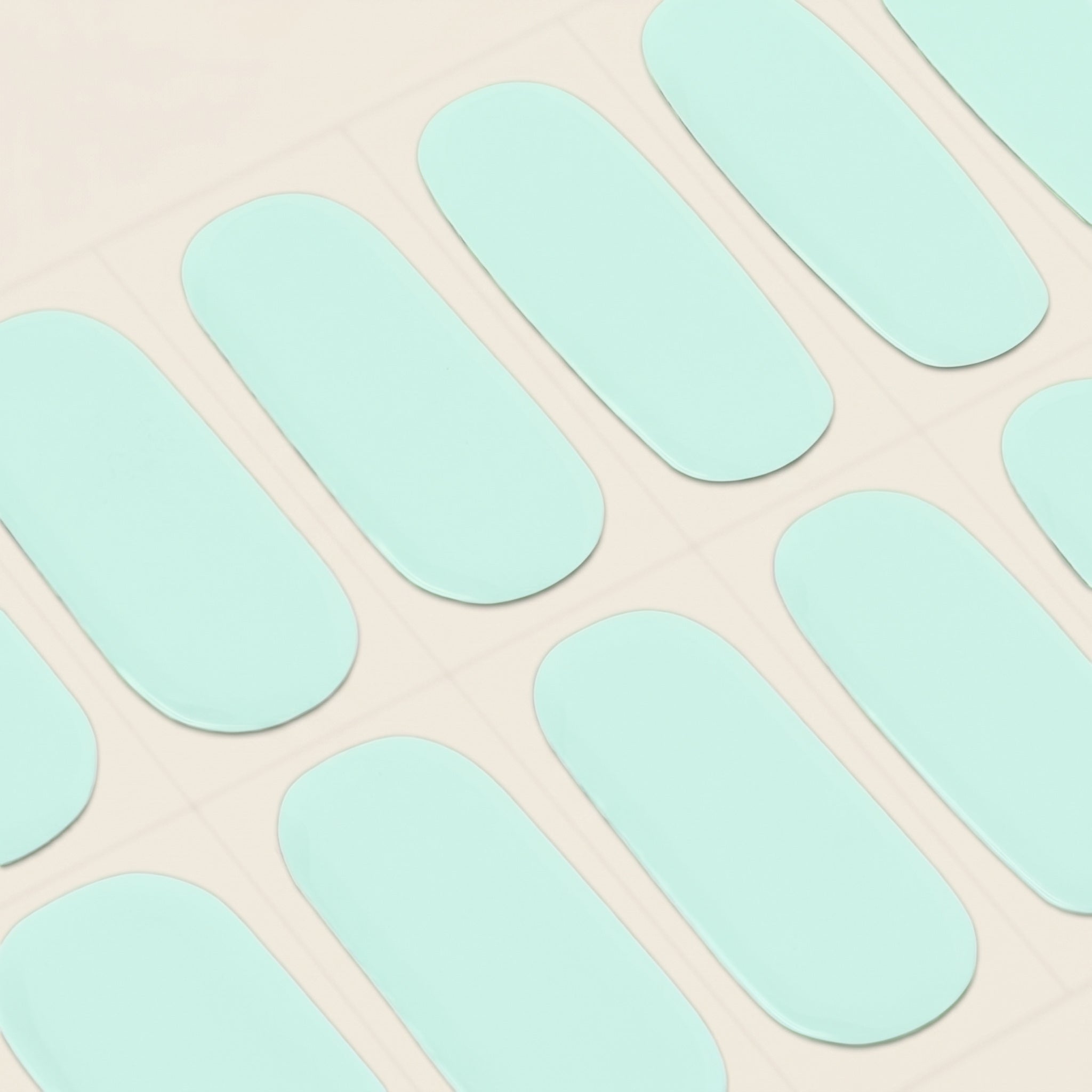 Close-up of seafoam mint mesme gel nail wraps on a sheet.