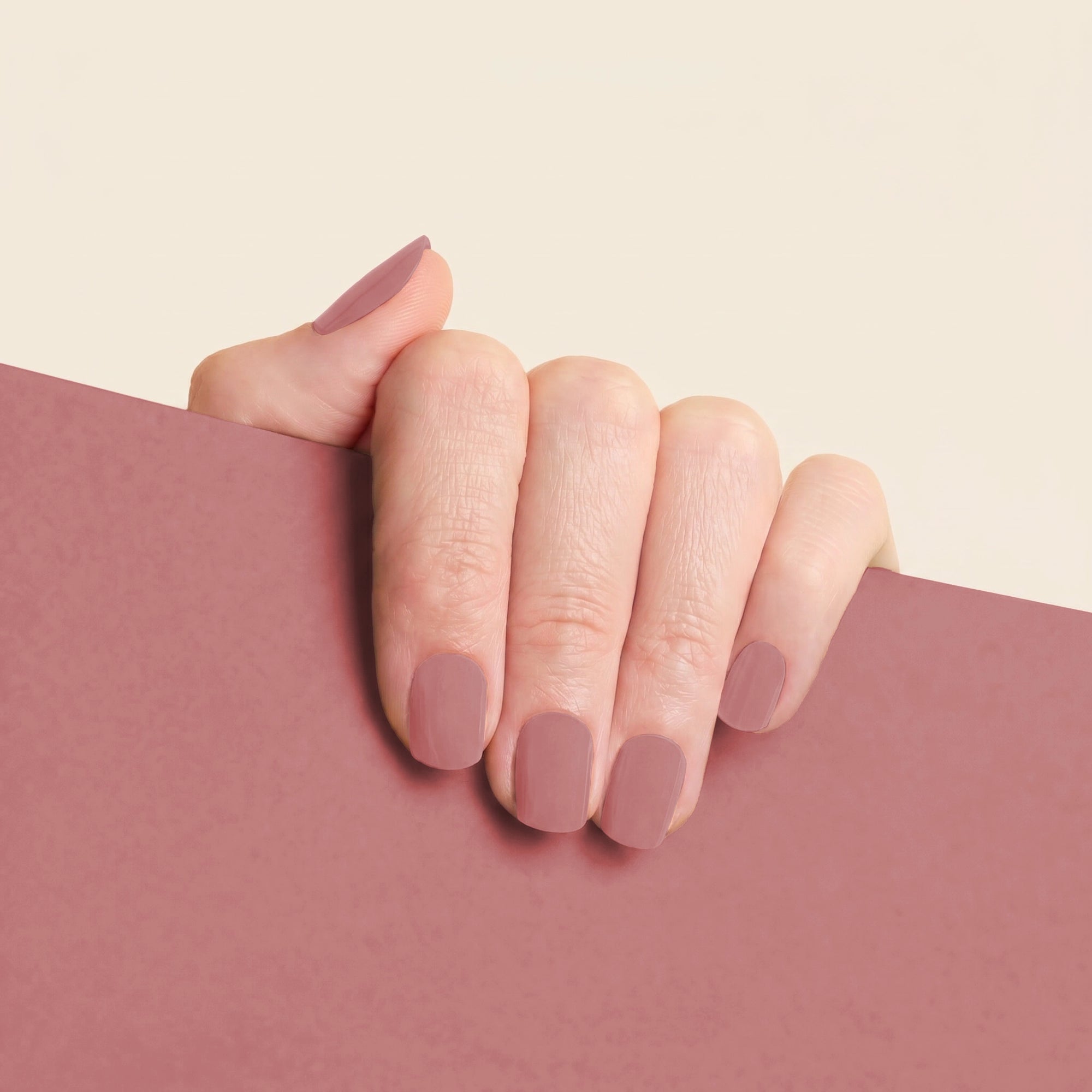 Hand wearing mesme Frankie STAY nail wraps in a soft dusty rose shade.